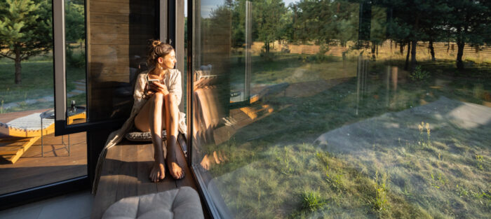 Koelte: Photo af a woman enjoying the sun behind her window  ta